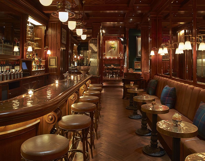 A warm, wood-paneled private club bar