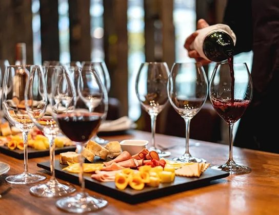 Wine being poured beside a charcuterie board at a Skeleton Key gathering